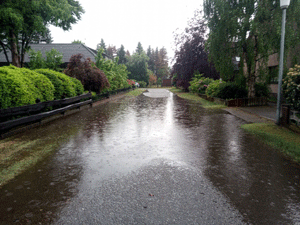 Wohnstraße nach starkem Regen unter Wasser