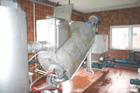 Ein rotierender Zylinder mit Rohrzu- und Ableitungen in einem Betriebsgebäude.