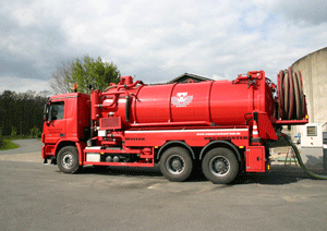 Ein so genannter Spülwagen: Drei-achsiger roter Tanklastzug mit aufgerollter Schlauchspindel am hinteren Ende