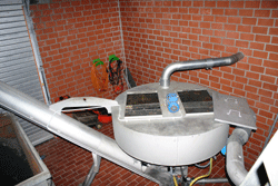 Ein kreisförmiger stahlbehälter mit mehreren Zu-und Ablaufrohren in einer Betriebshalle