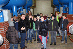 Eine Gruppe Jugendlicher steht zwischen den Kesselbehältern im Wasserwerk, ein Mitarbeiter erläutert die Zusammenhänge