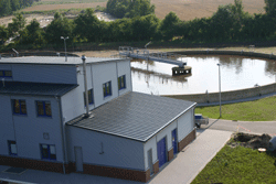 Luftbild des kreisrunden Belebungbeckens hinter dem Betriebsgebäude