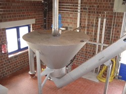 Eine trichterförmige Anlage mit mehreren Zu-und Ablaufrohren in einer Betriebshalle