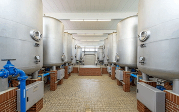 Zwei Reihen Kesselbehälter in der Halle eines Wasserwerks.