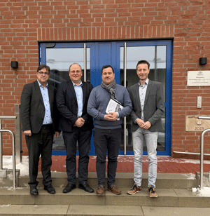 vier Männer stehen auf einer Treppe und blicken in die Kamera