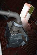 Ein offener Containerbehälter, darüber ein röhrenartiger Auslass für die Wertstoffe.