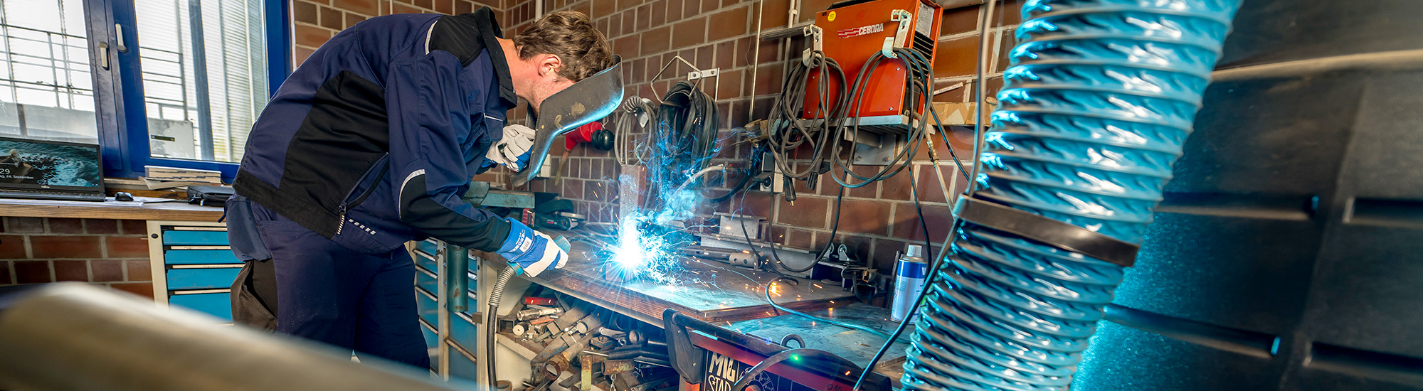 Junger Mann arbeitet in einer Werkstadt.