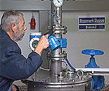 Ein Kontrolleur entnimmt im Wasserwek eine Trinkwasserprobe