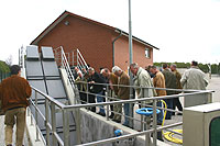 Eine Besuchergruppe steht am Geländer des Hebewerkes und schaut in den Schacht