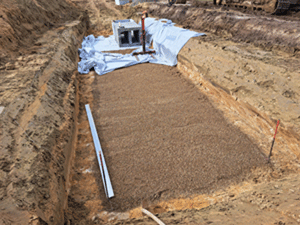 Baustelle mit Sand und Rigolen-Elementen zur Versickerung von Regenwasser.