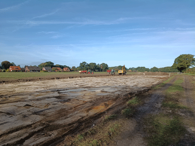 Landschaftliche umgebung mit Sonnenschein und blauem Himmel. gezeigt werden Erdarbeiten für ein Trockenbecken für Regenwasser